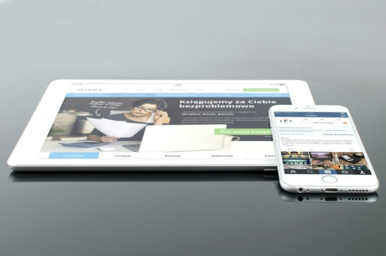 Modern tablet and smartphone displaying web content on a reflective surface, highlighting technology and connectivity.